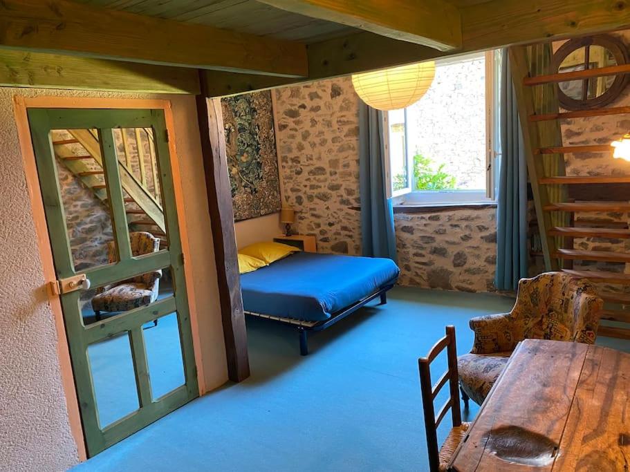 um quarto com uma cama, uma mesa e uma janela em Domaine de Linars ☆ La Forge ☆ em Le Truel