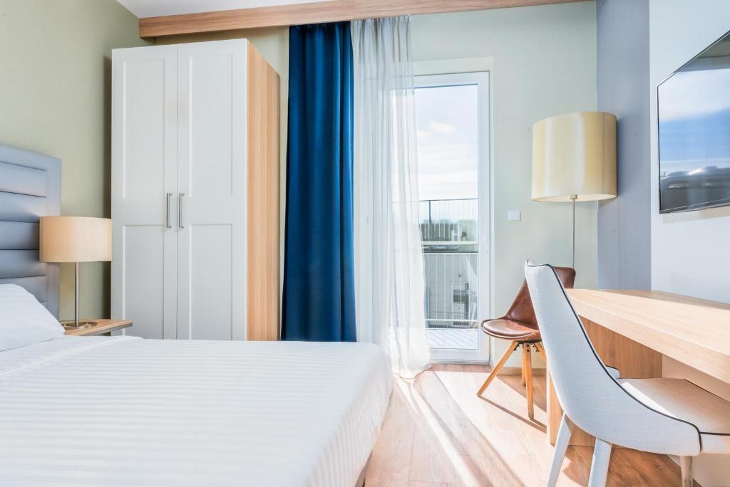 ein Hotelzimmer mit einem Bett, einem Schreibtisch und einem Fenster in der Unterkunft Akeah Verdi Budapest in Budapest