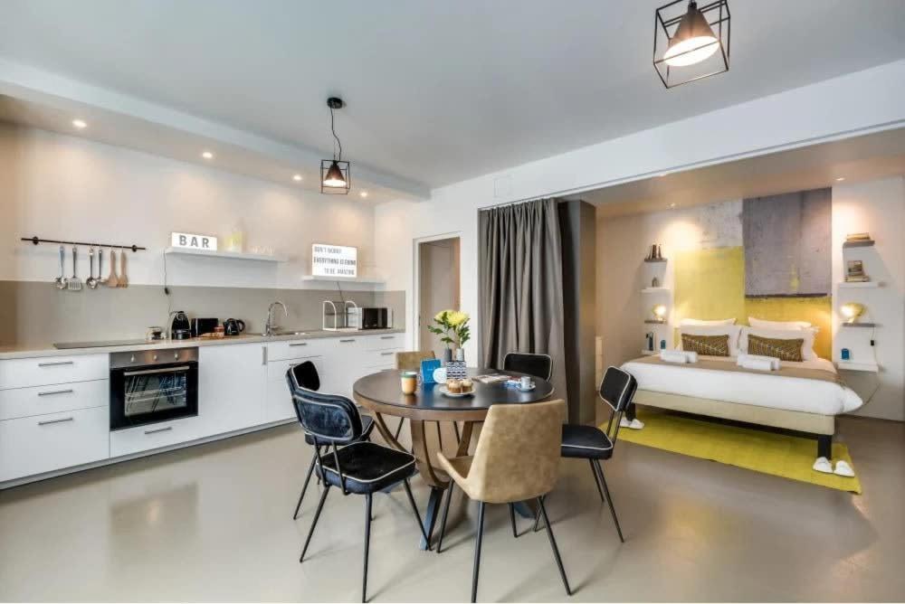 une cuisine et un salon avec une table et un lit dans l'établissement Modern and eclectic 3BD duplex in Le Marais!, à Paris