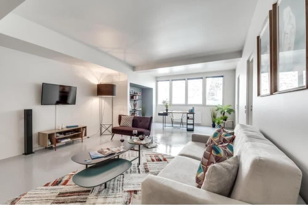 un salon avec un canapé et une table dans l'établissement Modern and bright 2BD for 11 guests in Le Marais!, à Paris