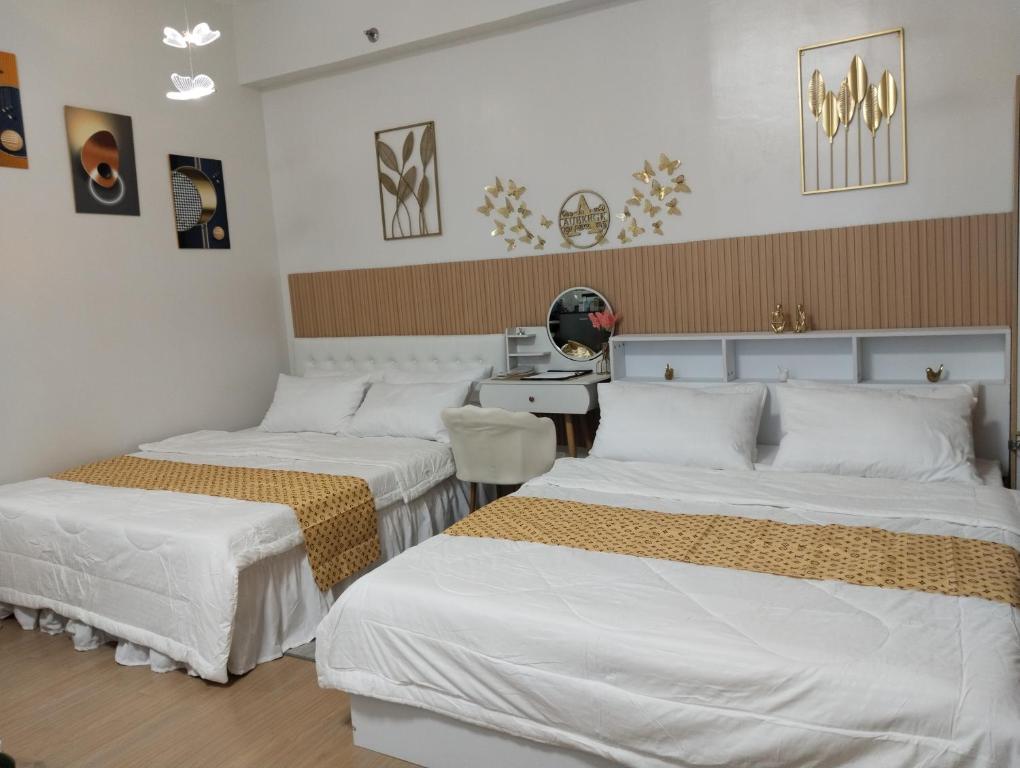 a bedroom with two beds and a desk at Auberge at SMDC Hope Residences in Trece Martires