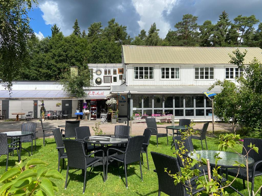 un grupo de mesas y sillas frente a un edificio en Modern vindsvåning ovanpå café ute på landet. en Hökerum