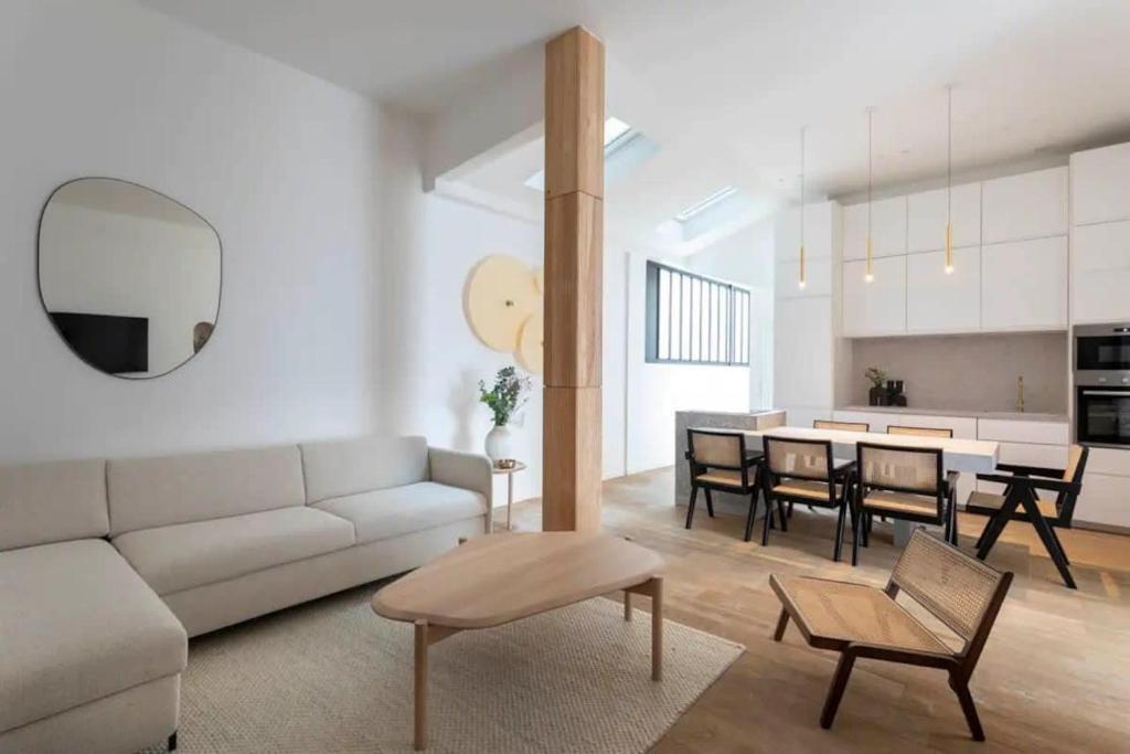 un salon avec un canapé et une salle à manger dans l'établissement Tour Eiffel - Champ de Mars Exquisite 3BD 3BTH, à Paris