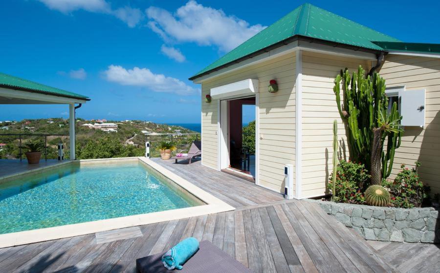 une maison avec une piscine sur une terrasse en bois dans l'établissement Luxury Vacation Villa 17, à Le Marigot