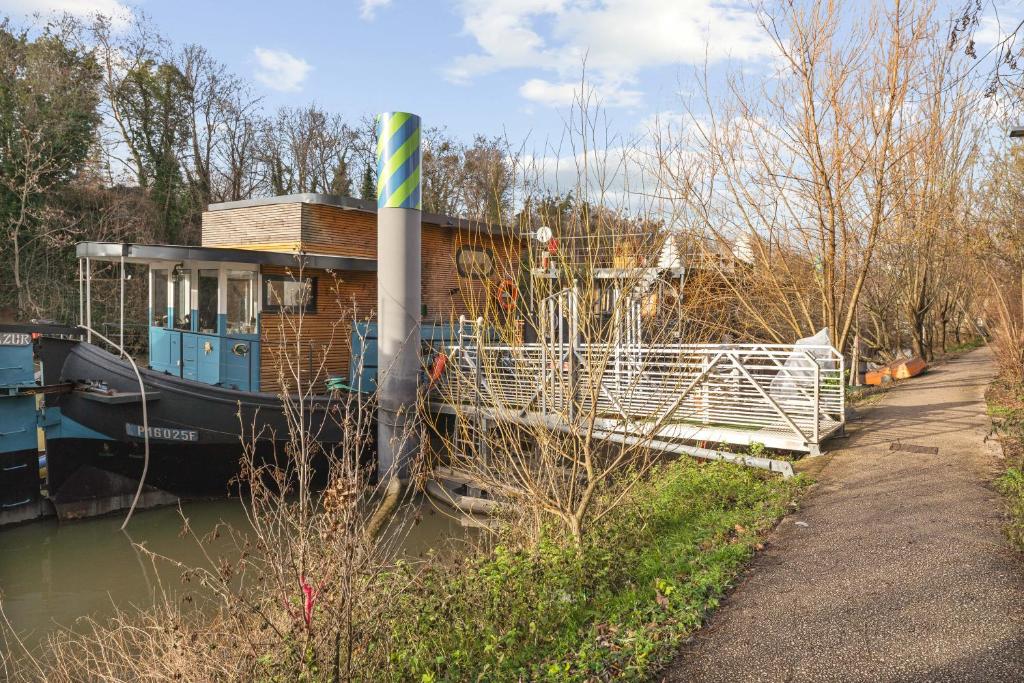 a house boat is docked next to a dock at Péniche in Issy-les-Moulineaux