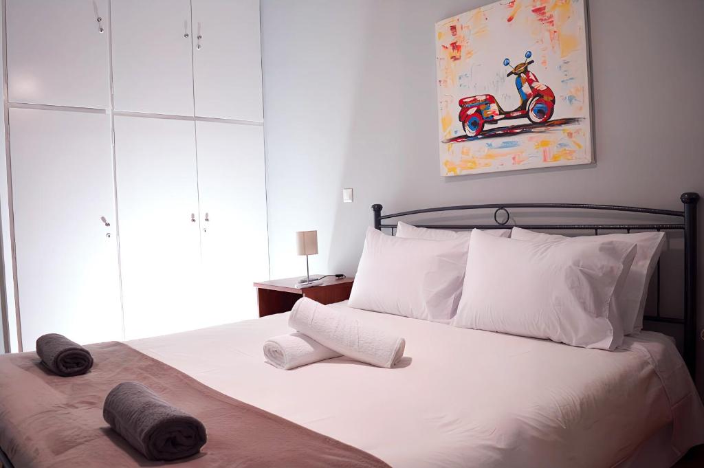 een slaapkamer met een bed met witte kussens bij Modern 2 BR apartment near Acropolis in the heart of the city - Explore Center by foot in Athene
