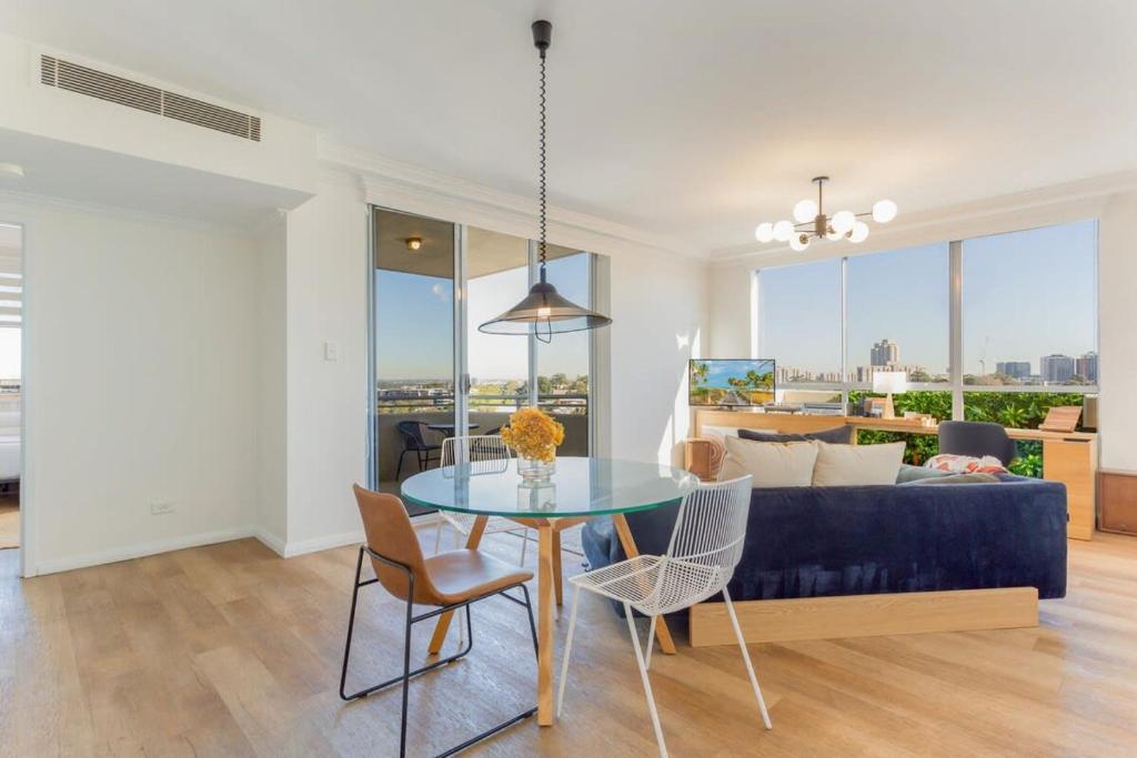 uma sala de estar com uma mesa e um sofá em Bright and Modern Apartment in Amazing Location em Sydney