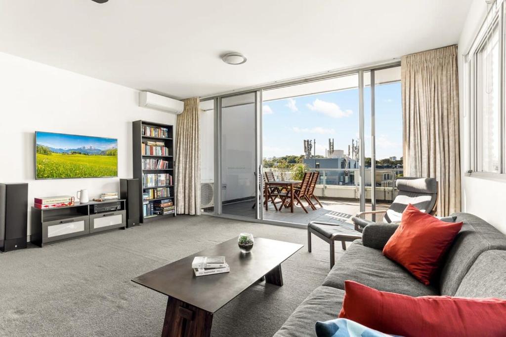 a living room with a couch and a table at Spacious 2-Bed with Two Balconies with City Views in Sydney
