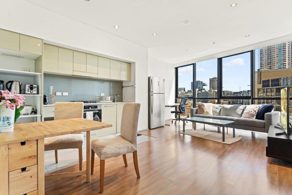 a kitchen and living room with a table and chairs at Modern 1-Bed in CBD with Views near Chinatown in Sydney