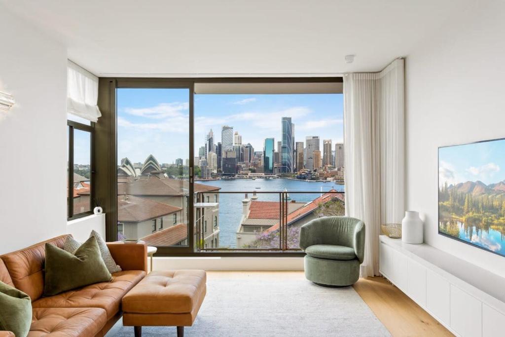 a living room with a couch and a large window at Boutique 2-Bed with Stunning Sydney Harbour Views in Sydney