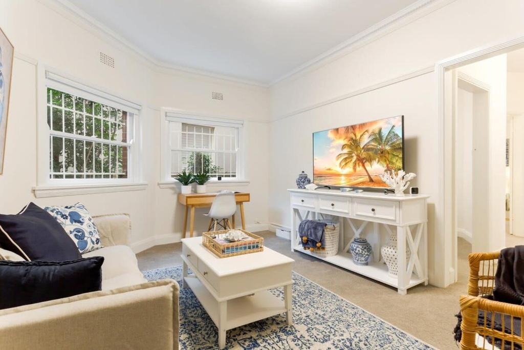 uma sala de estar com um sofá e uma lareira em Art Deco Apartment Meters Away From The Beach em Sydney