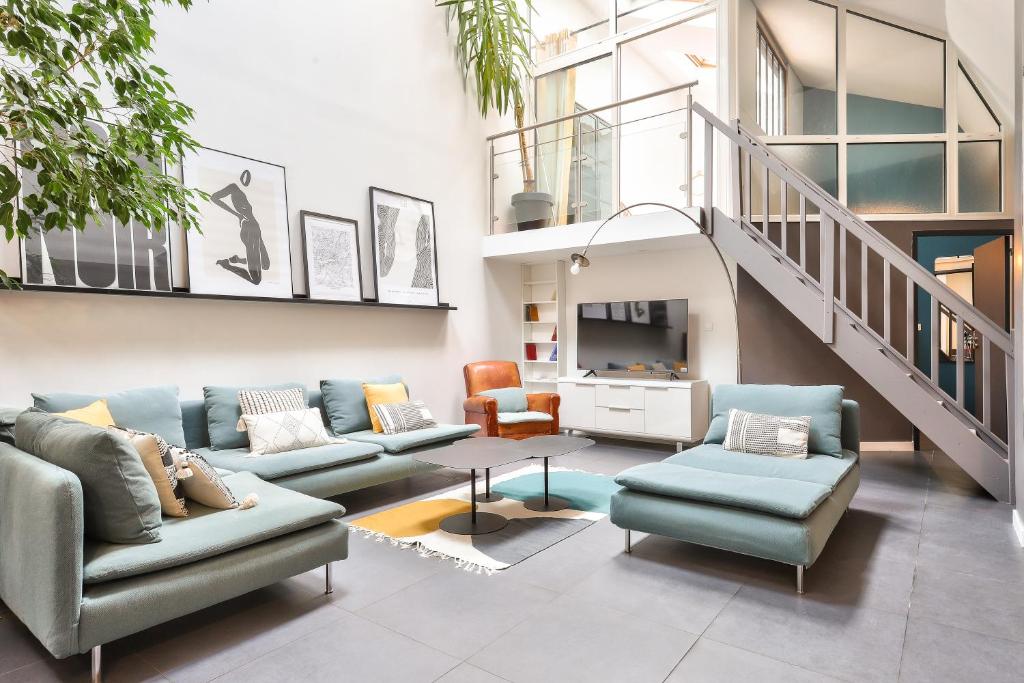 - un salon avec des canapés bleus et un escalier dans l'établissement NOCNOC Loft L'atypique - 185m2 Centre de Nantes, à Nantes