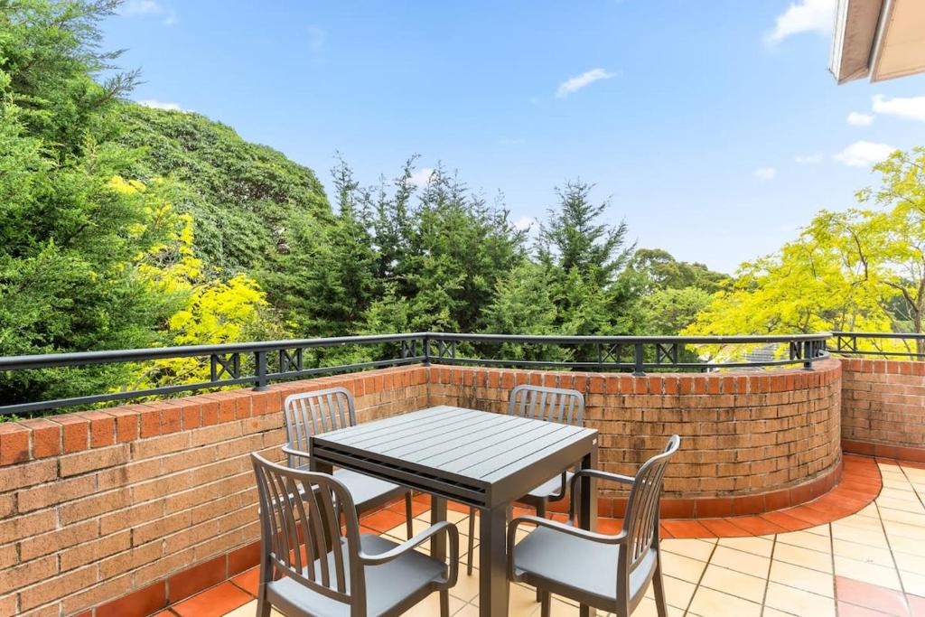 a patio table and chairs on a brick wall at Pristine 2-Bed Near Marrickville Village in Sydney