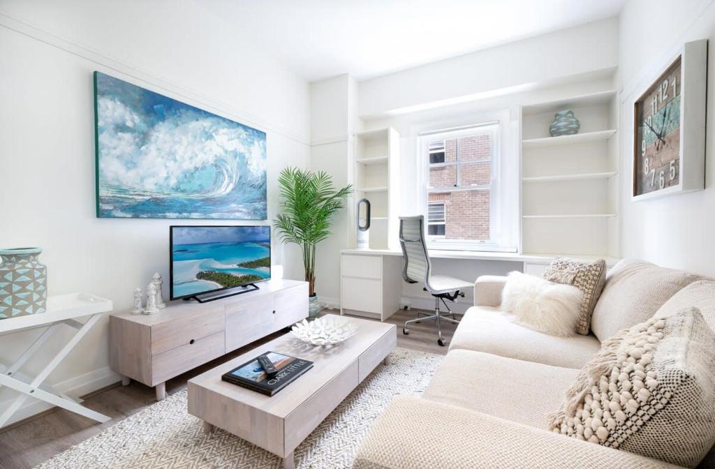 a living room with a couch and a tv at Snug 1-Bed Unit Across from Bondi Beach in Sydney