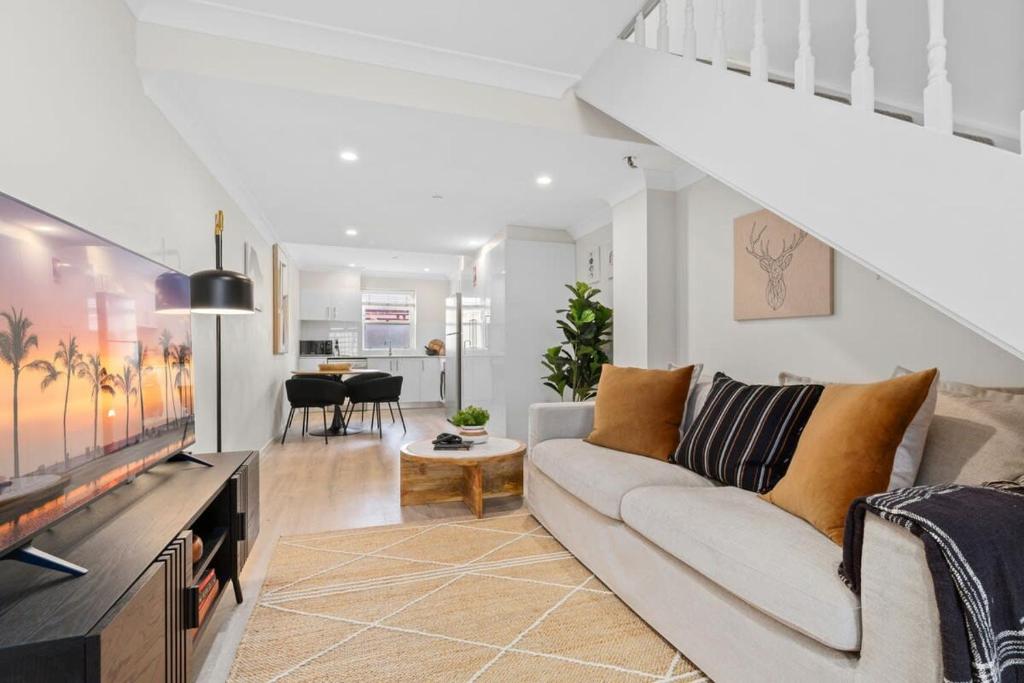 a living room with a couch and a tv at Chic 2-Bed Unit Fully Renovated in Prime Location in Sydney