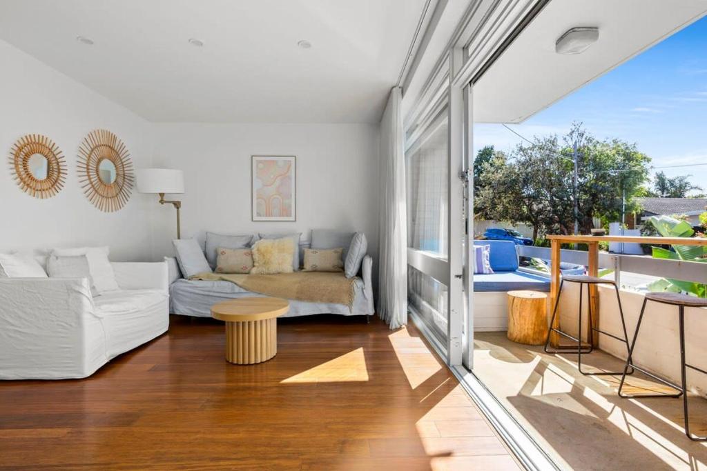 een woonkamer met een bank en een tafel bij Beautiful Boho 3-Bed by the Beach & the Bush in Sydney