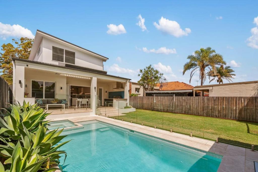 a home with a swimming pool and a fence at Impeccably Chic 4-Bed Home with Spa & Pool in Sydney