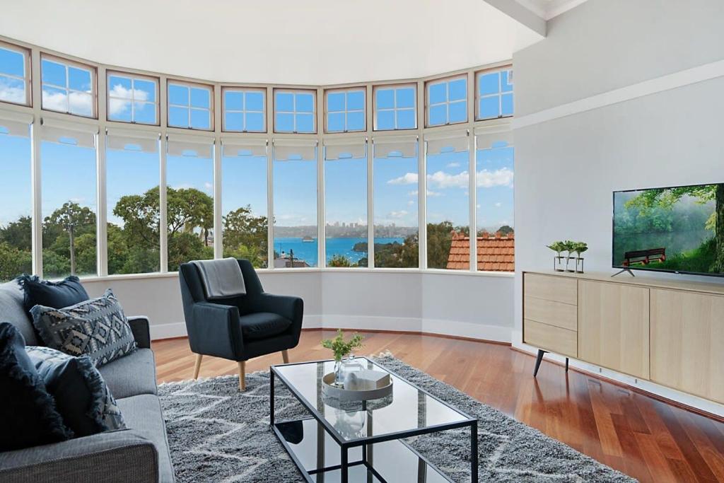 a living room with a couch and a tv at Huge Harbour View Apartment In Historic Home in Sydney