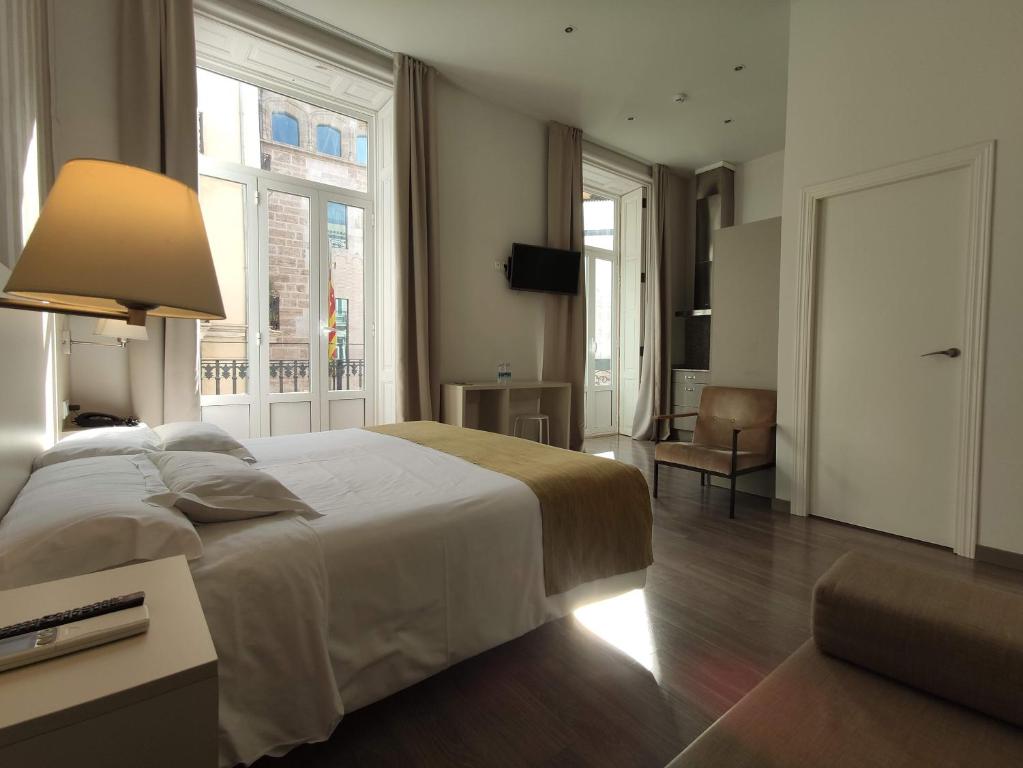 een slaapkamer met een groot wit bed en een raam bij Hotel San Lorenzo Boutique in Valencia