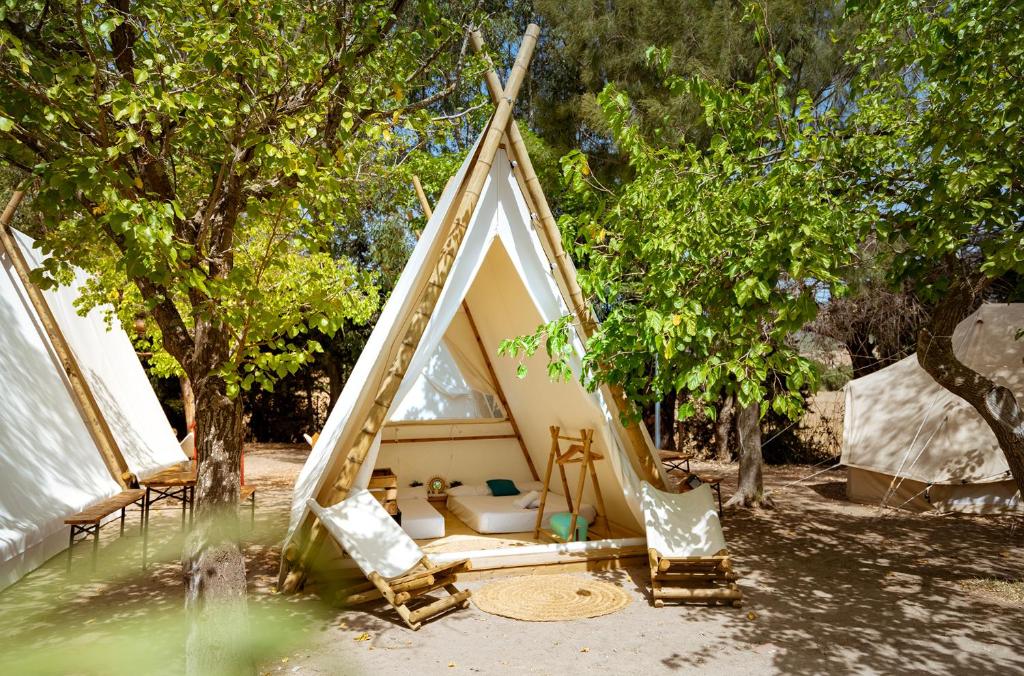 a tent with a bed in the middle of trees at Kampaoh Paloma in Tarifa