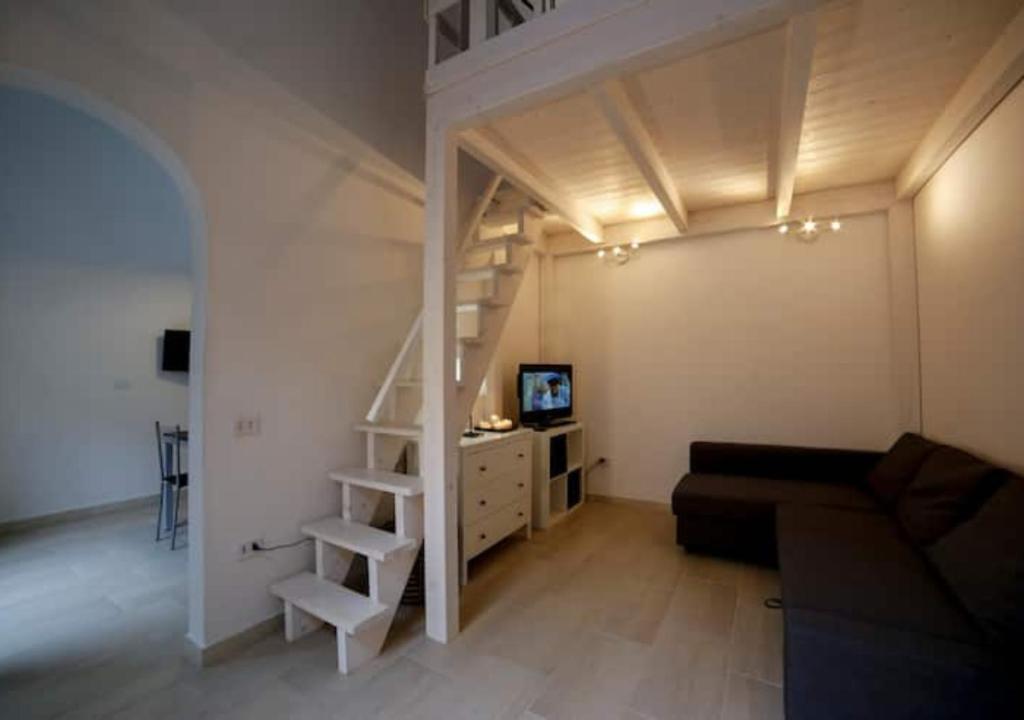 - un salon avec une mezzanine et un canapé dans l'établissement La Casetta Del Mare in Toscana, à Marina di Pisa
