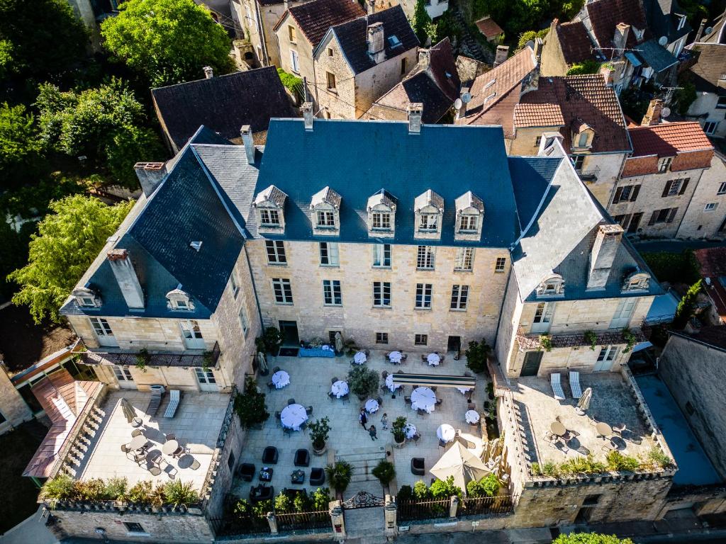 - une vue aérienne sur une grande maison avec une cour dans l'établissement Hôtel Restaurant de Bouilhac, Spa & Wellness - Les Collectionneurs, à Montignac