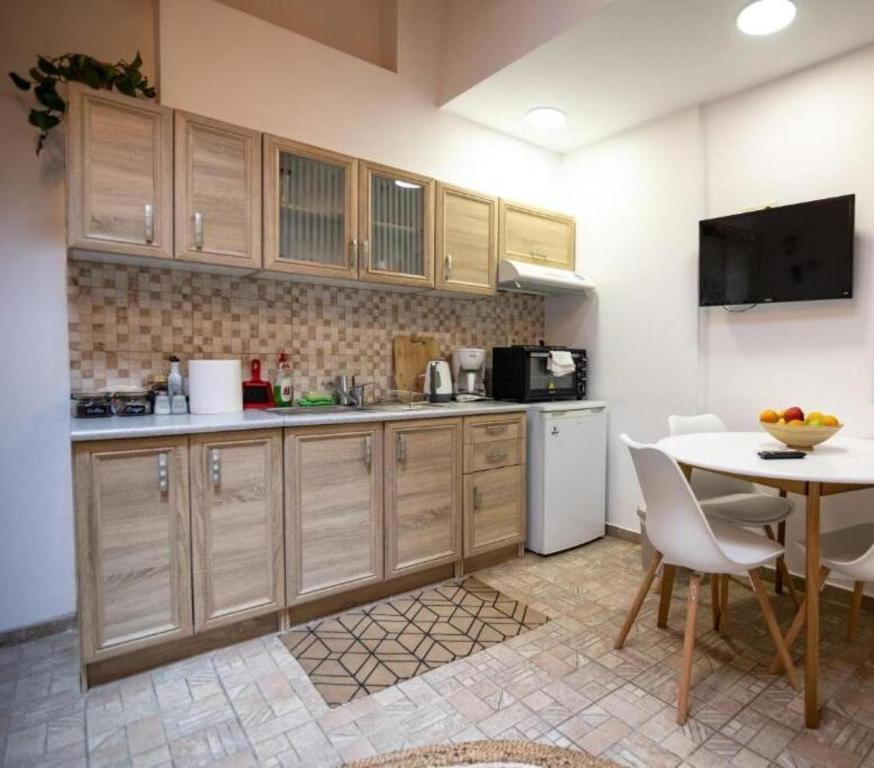 a kitchen with wooden cabinets and a table at Apeiron Acropolis Suites in Athens