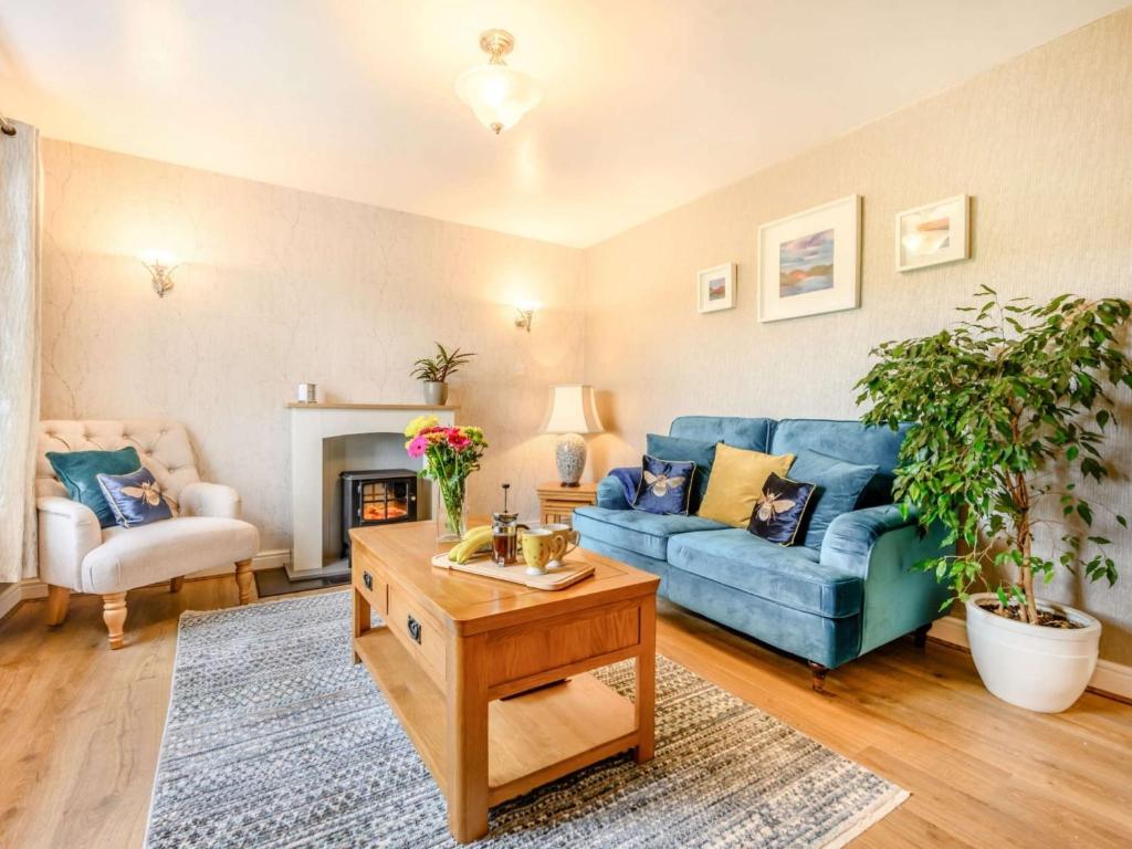 a living room with a blue couch and a table at 1 Bed in Bassenthwaite 88490 in Bassenthwaite Lake