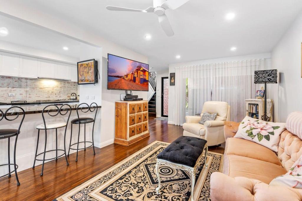 a living room with a couch and a kitchen at Delightful 2-Bed Townhouse Close to the Beach in Frankston