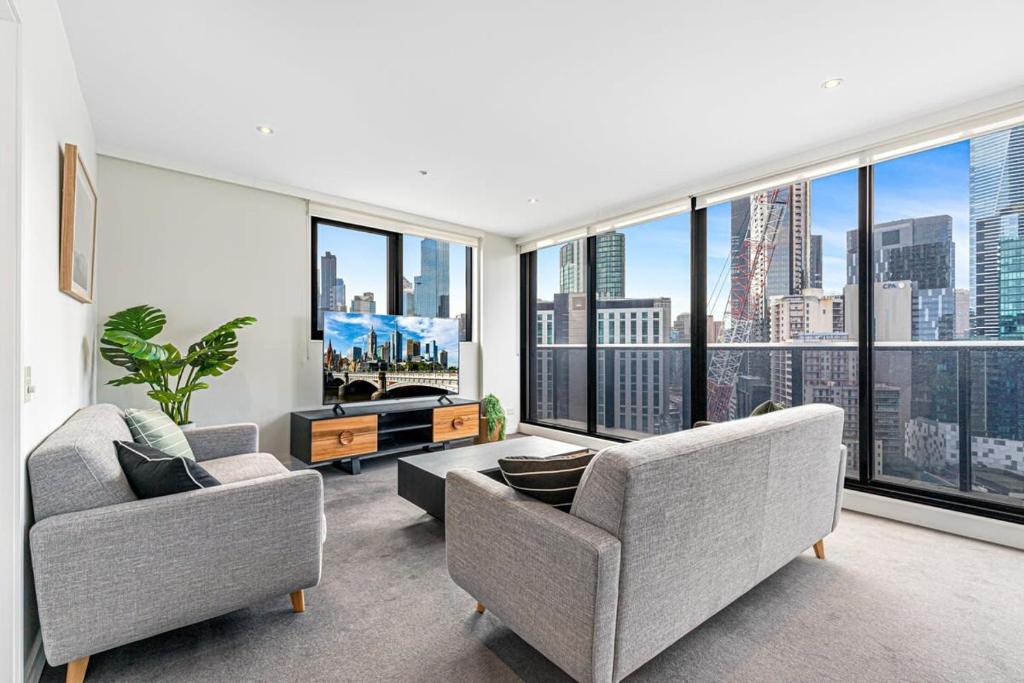 salon z 2 krzesłami i dużym oknem w obiekcie Pristine 2-Bed Unit With Beautiful City Landscape w Melbourne