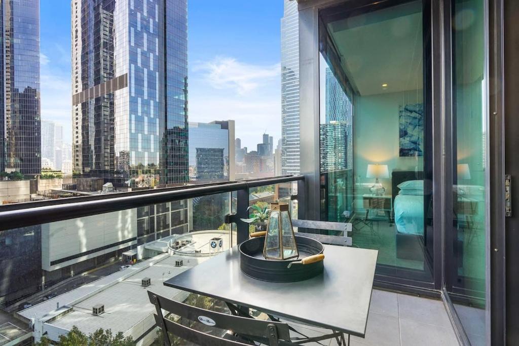 balcón con mesa y vistas a la ciudad en Southbank Central 2-Bed - Pool, Gym & City Views, en Melbourne
