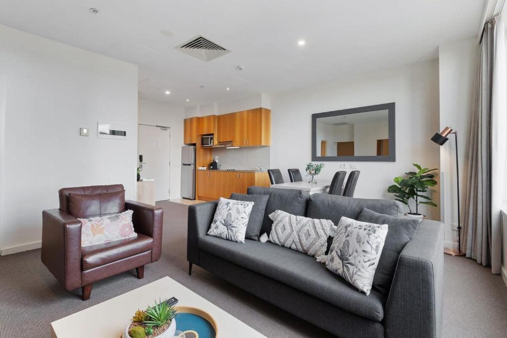 ein Wohnzimmer mit einem Sofa und einem Stuhl in der Unterkunft Unbeatable 2-Bed Apartment In City Centre in Melbourne