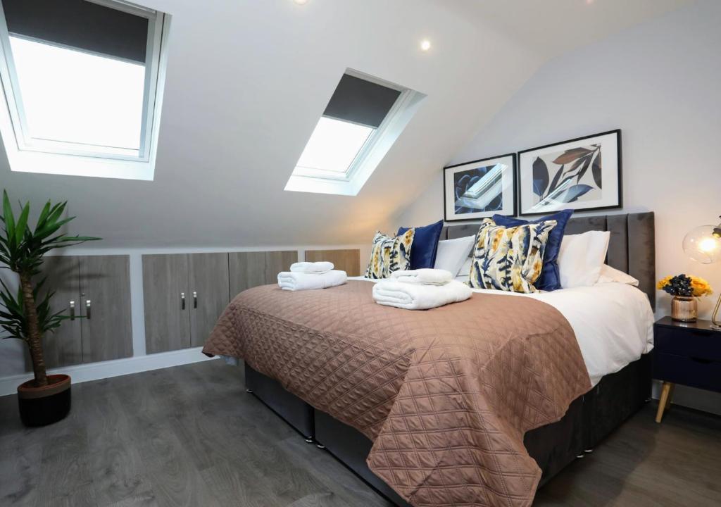een slaapkamer met een bed met handdoeken erop bij Aisiki Apartments at Stanhope Road, North Finchley, a Multiple 2 or 3 Bedroom Pet-Friendly Duplex Flats, King or Twin Beds with Aircon & FREE WIFI in Finchley