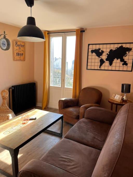 un salon avec un canapé et une table dans l'établissement Le cozy des tuilières, 2 ch, à Limoges