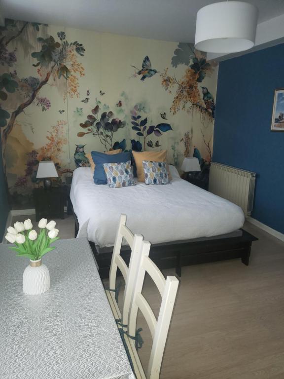 sypialnia z łóżkiem i stołem z wazonem kwiatów w obiekcie Chez Bouju w mieście Castetnau-Camblong