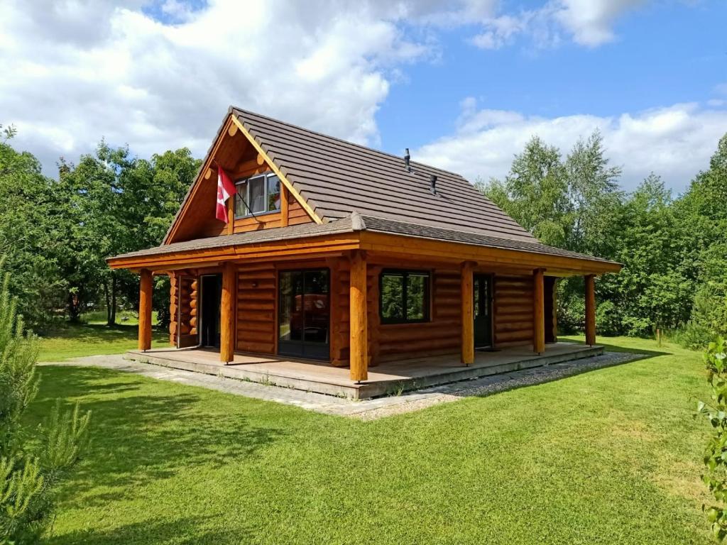 una cabaña de madera con techo de gambrel en Unieke houten villa met SAUNA in Twente - 6p, en Den Ham