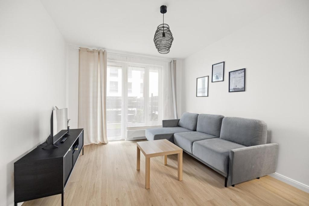 Apartament Blisko Morza Gdańsk في غدانسك: غرفة معيشة مع أريكة وتلفزيون