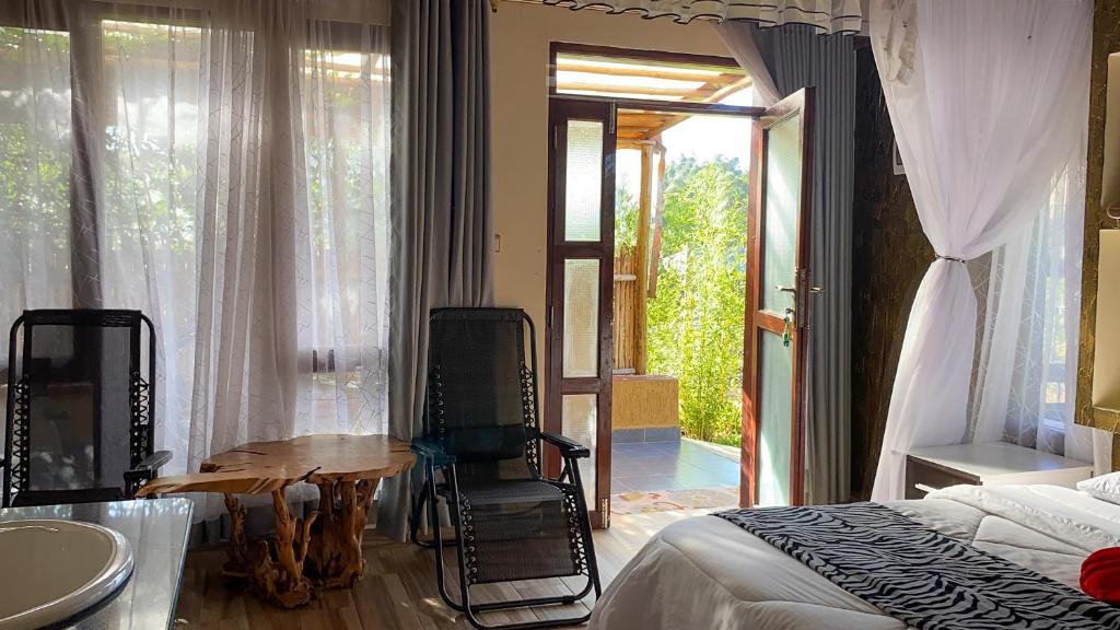 a bedroom with a bed and a table and chairs at Tiret Riverside Resort and Retreat in Eldoret