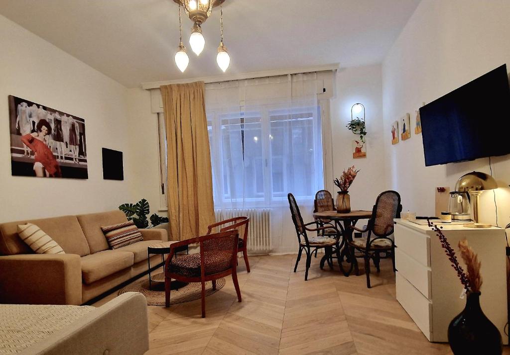 ein Wohnzimmer mit einem Sofa und einem Tisch in der Unterkunft Charming Apartman in Budapest
