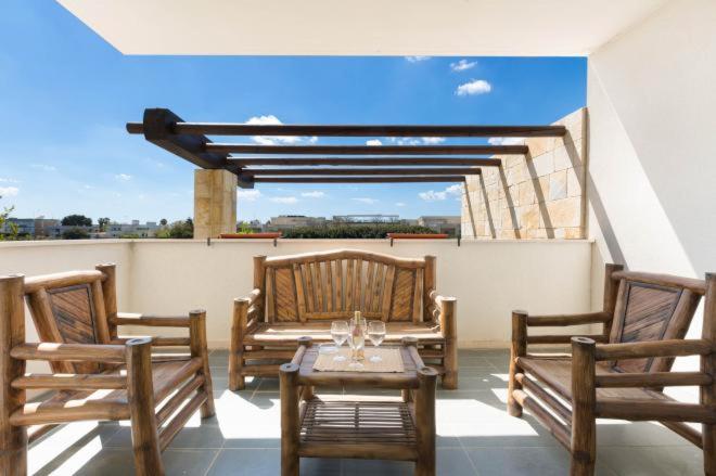 ポルト・チェザーレオにあるAppartamento del Tramonto by Le Dune Villasの屋上に椅子3脚とテーブルが備わるパティオ