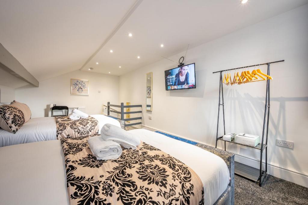 a bedroom with two beds and a tv on the wall at *RA10W* For your most relaxed & Cosy stay + Free Parking + Free Fast WiFi * in Belle Isle
