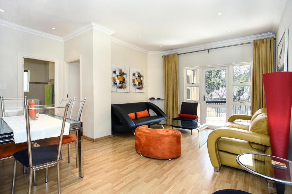 een woonkamer met een bank en een tafel bij The Melrose Kernick Avenue Apartment in Johannesburg