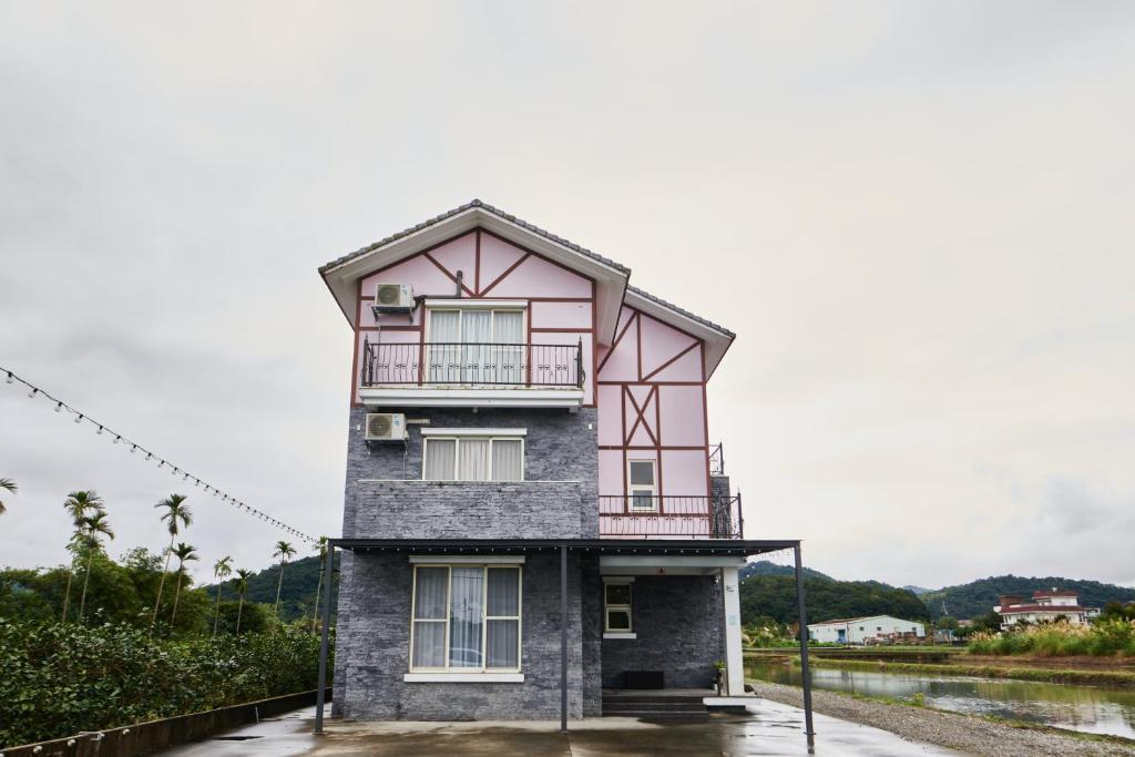 a pink and gray building with a balcony at 旅居Villa in Dongshan