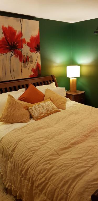 a bedroom with a large white bed with a green wall at Hill House Lodge in Stoke Gabriel