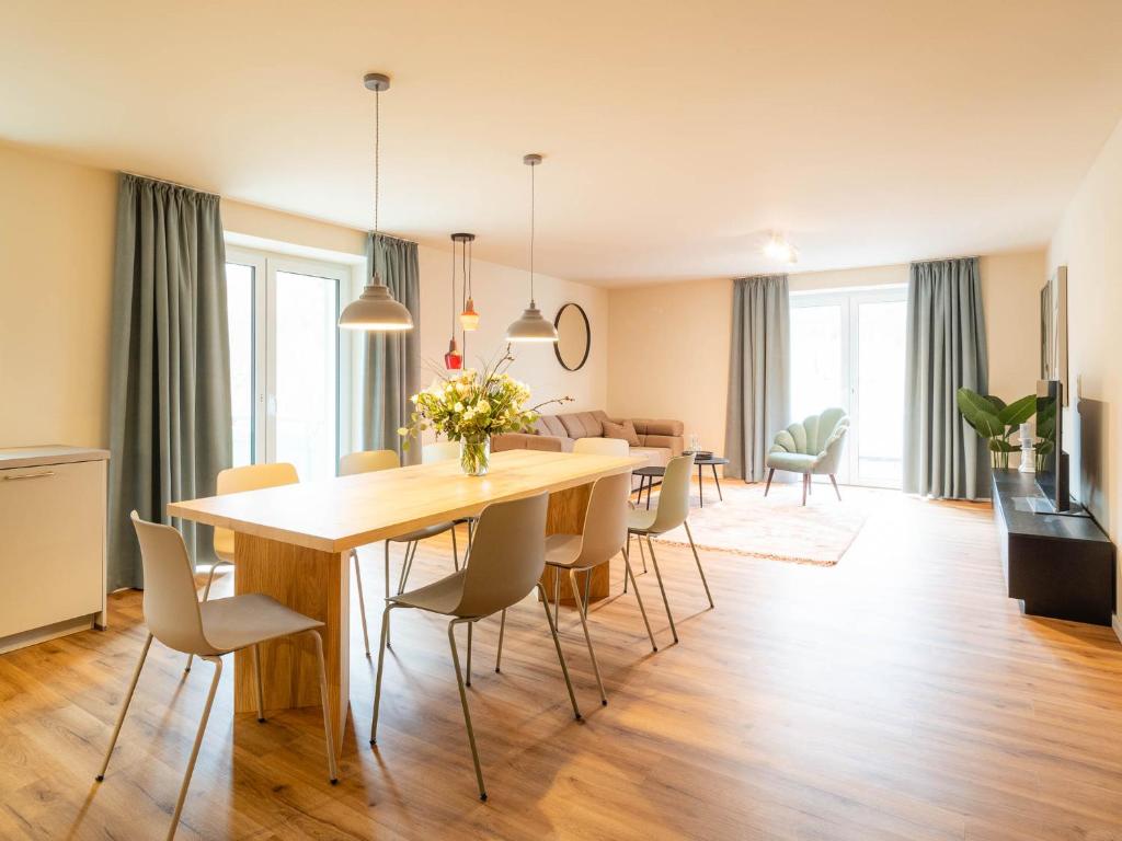 a dining room and living room with a table and chairs at Domizil am Gohrisch in Kurort Gohrisch