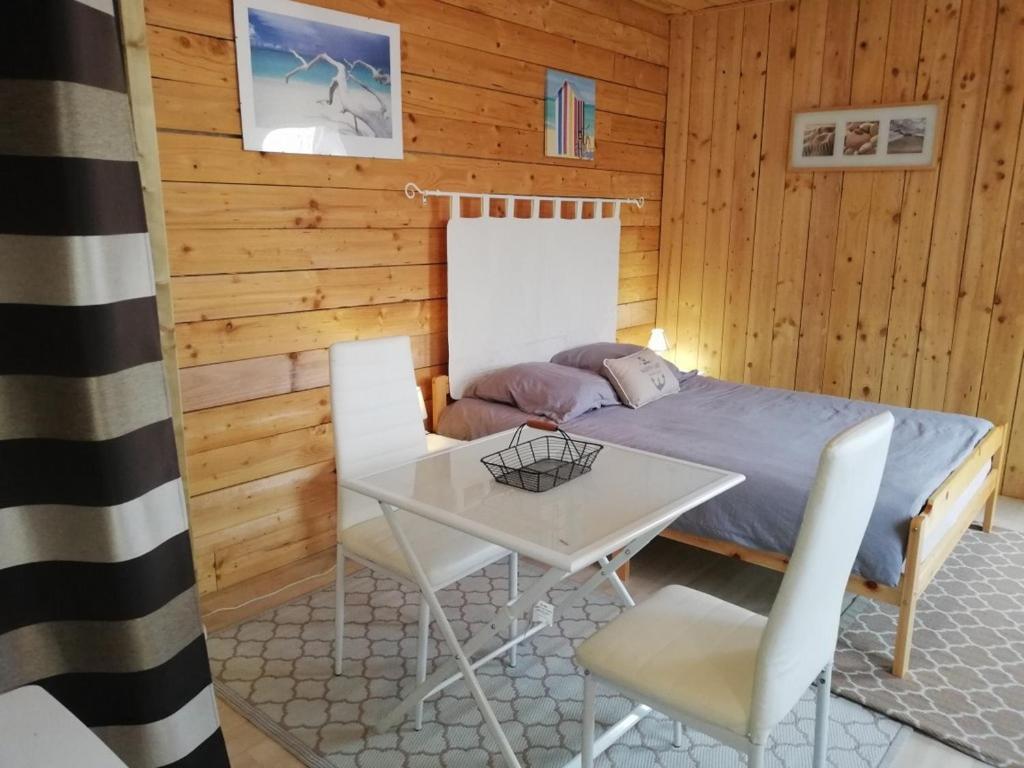 Schlafzimmer mit einem Bett, einem Tisch und Stühlen in der Unterkunft CHAMBRE LA NOE in Saint-Cast-le-Guildo