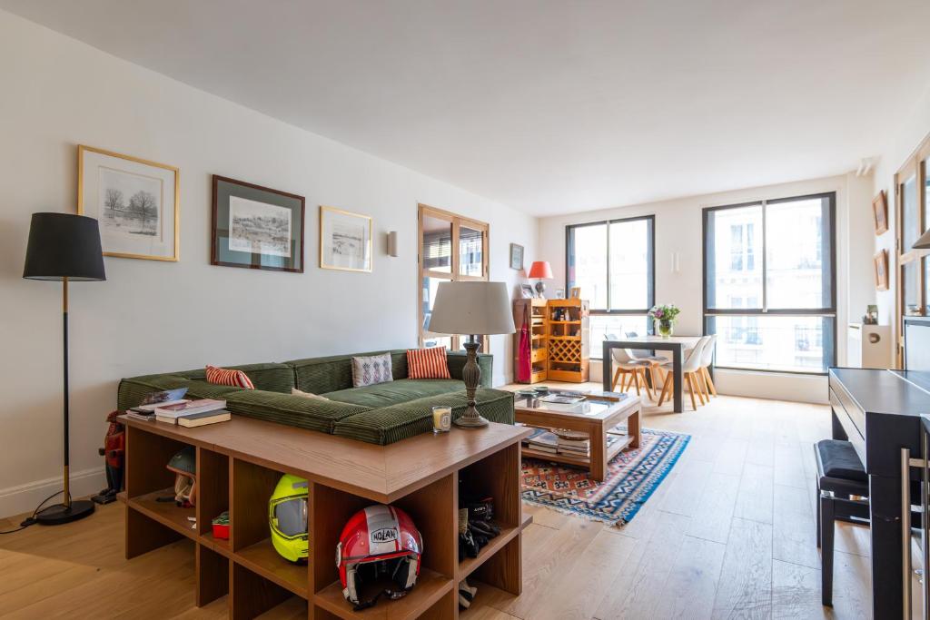 un salon avec un canapé vert et une table dans l'établissement Veeve - Footsteps From Trocadéro, à Paris