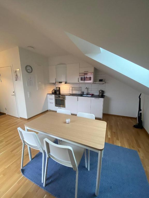 Cozy And Luxury Private Terrace Apartment في غوتنبرغ: طاولة طعام مع كراسي بيضاء ومطبخ