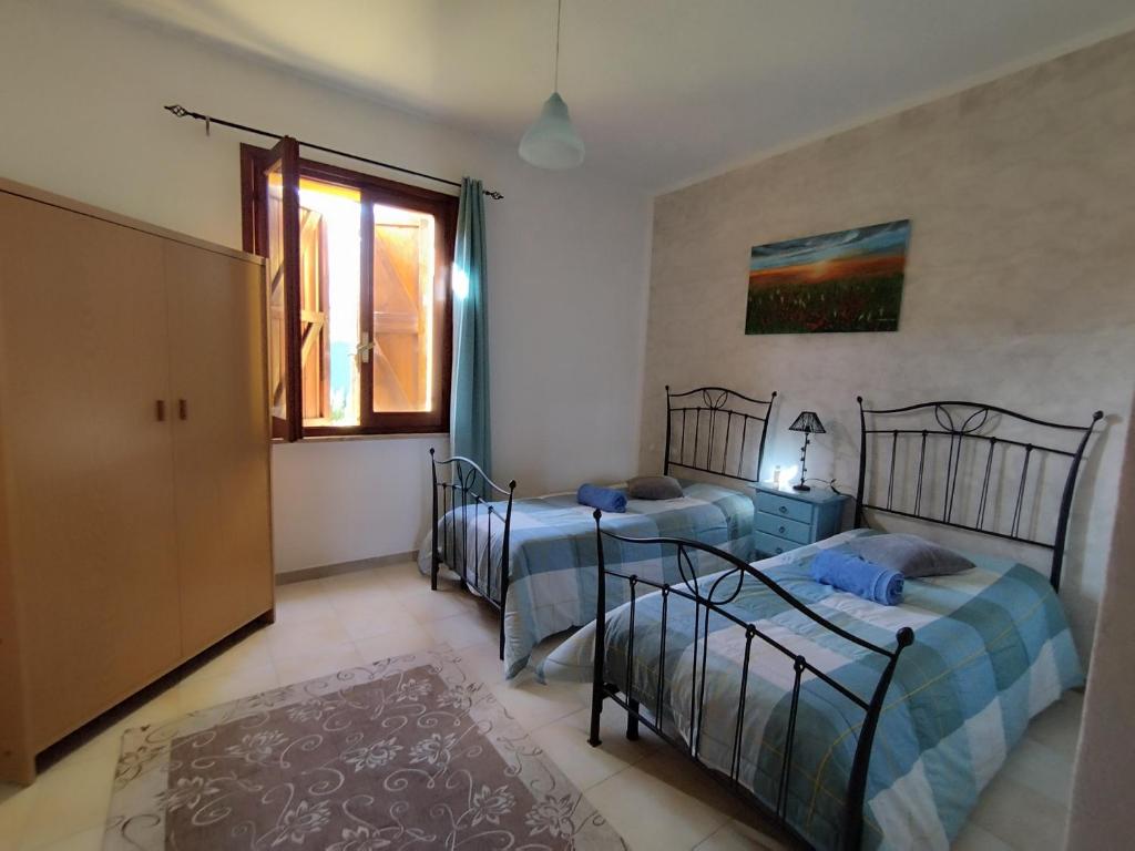 a bedroom with two beds and a window at Areamare in Sorso