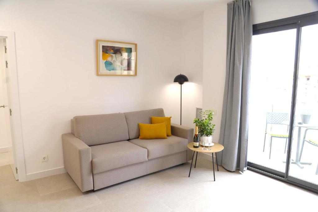 sala de estar con sofá y mesa en Cosmo Apartments Consell de Cent - Plaza Universitat, en Barcelona